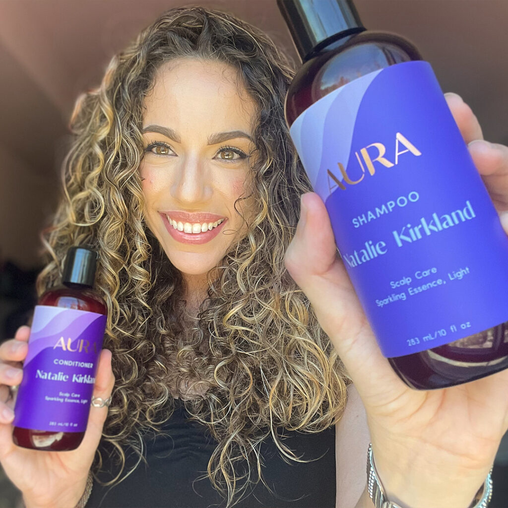 Natalie showing off her AURA personalized hair care Ritual with a smile 