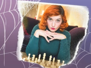 Girl posing over a chess board with red, vintage-inspired hair