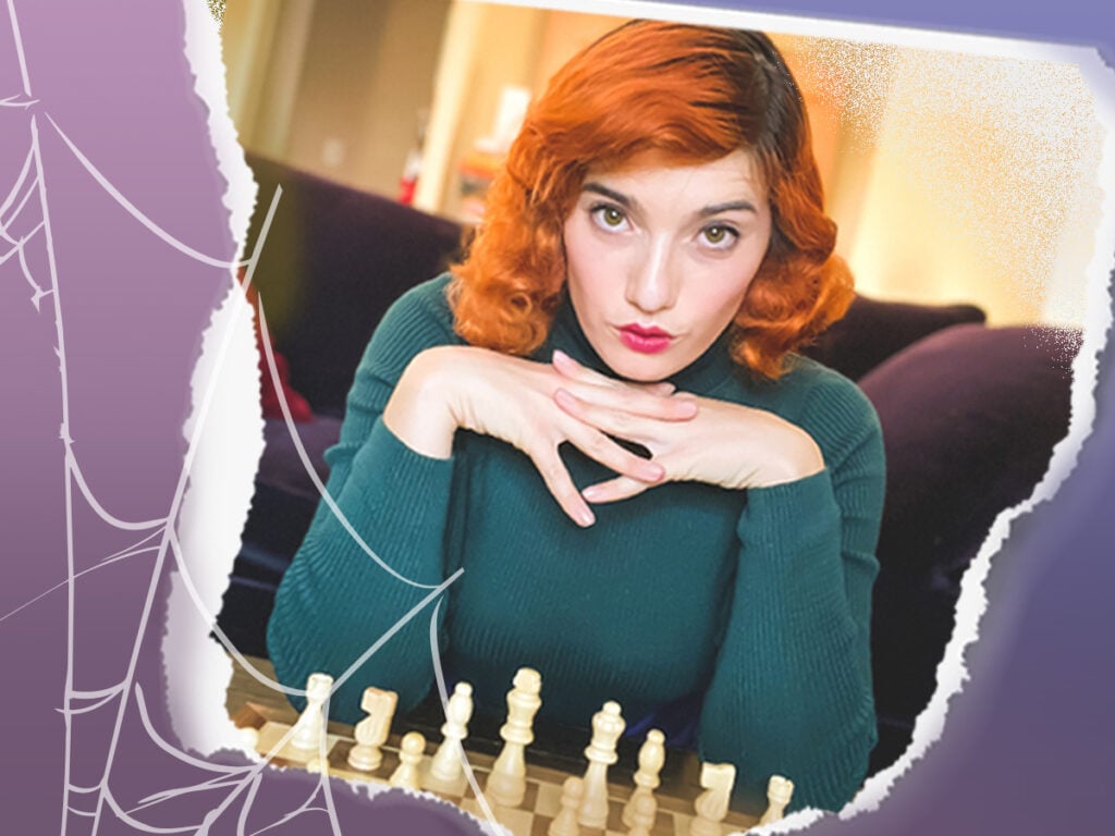 Woman posing over a chess board with red, vintage-style hair