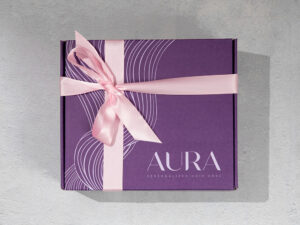An AURA box wrapped with a pink bow