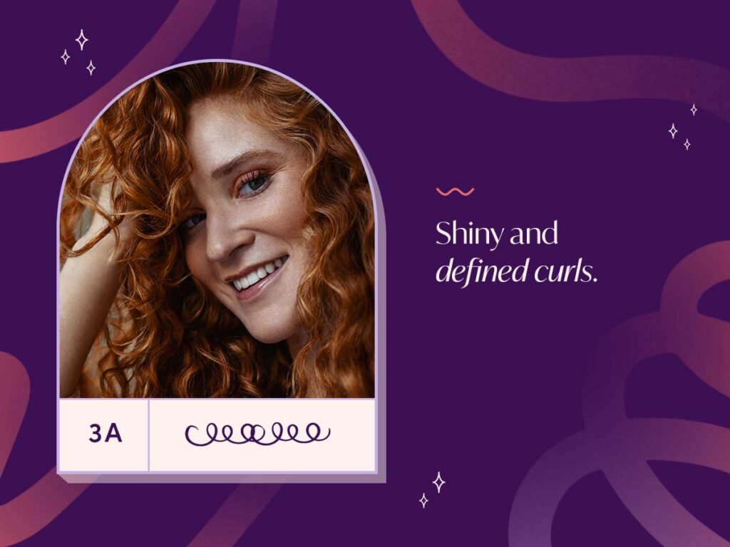Graphic with image of a smiling, red haired woman with defined Type 3A curls. 
Definition of Type 3A: Shiny, defined curls. 