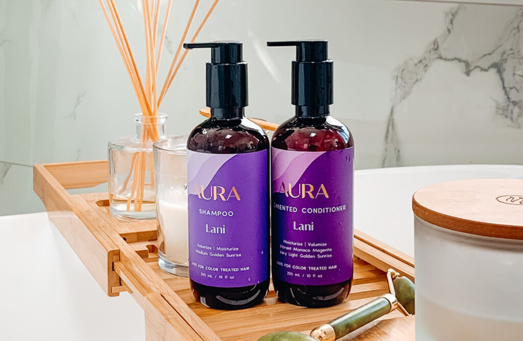 A bottle of personalized shampoo and conditioner on a bath tray.