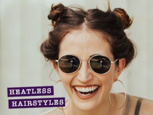 Woman laughing with hair in two buns hairstyle.