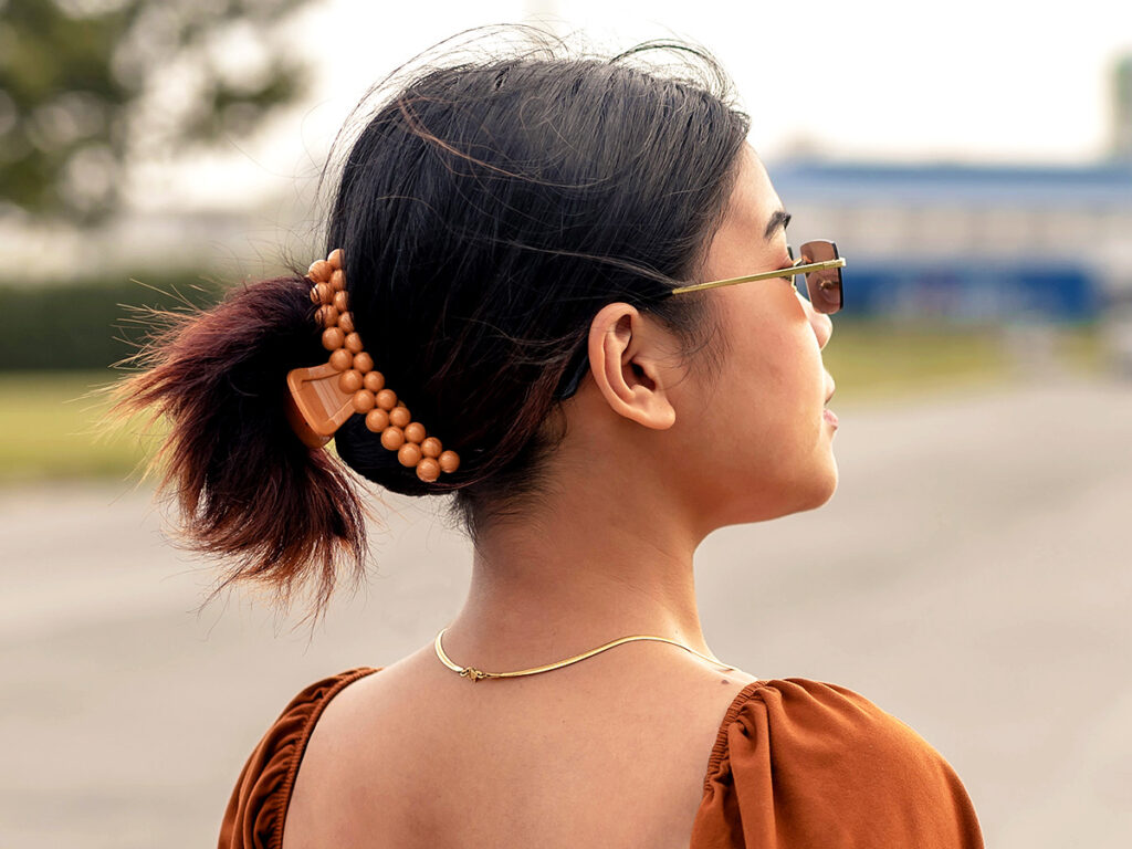 Woman with sunglasses and a claw clip in her hair.