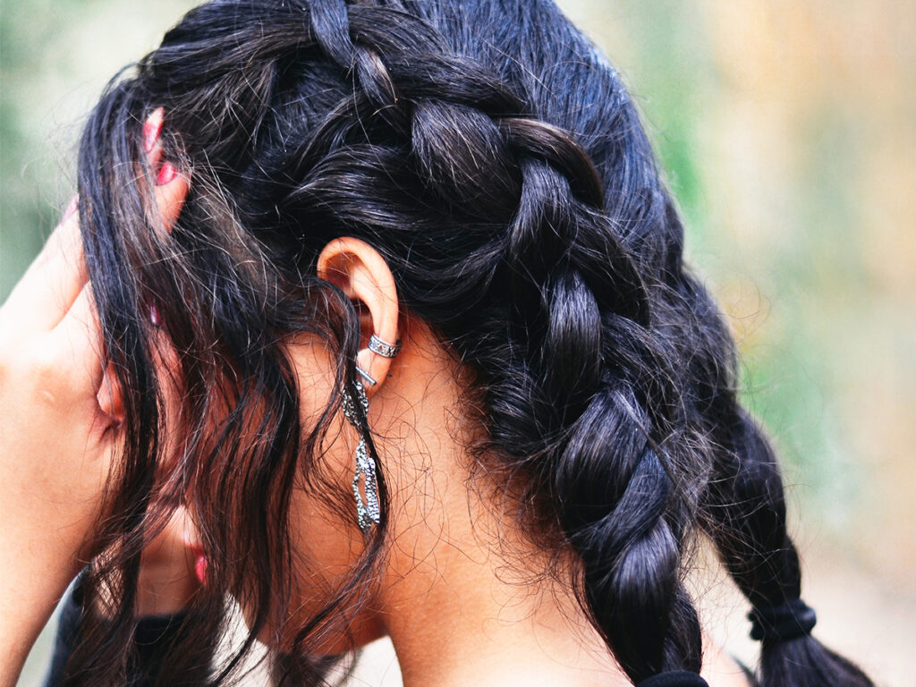 Woman with dark hair in two braids. 